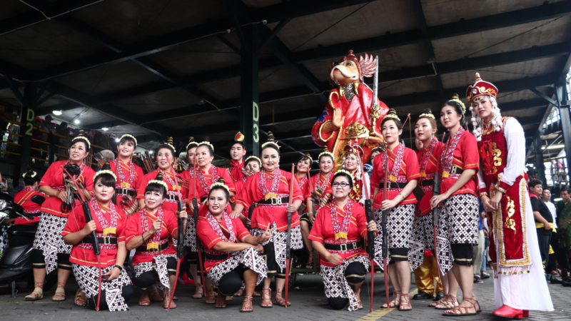 Tour guide team of females in Asia post in traditional costumes.