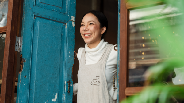 An Asian shopkeeper opens the door