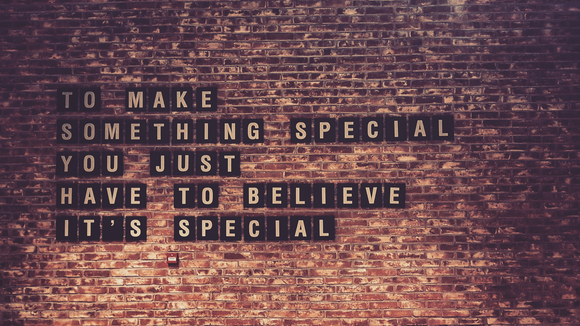 Sign on a brick wall that reads 'to make something special. you just have to believe it is special'